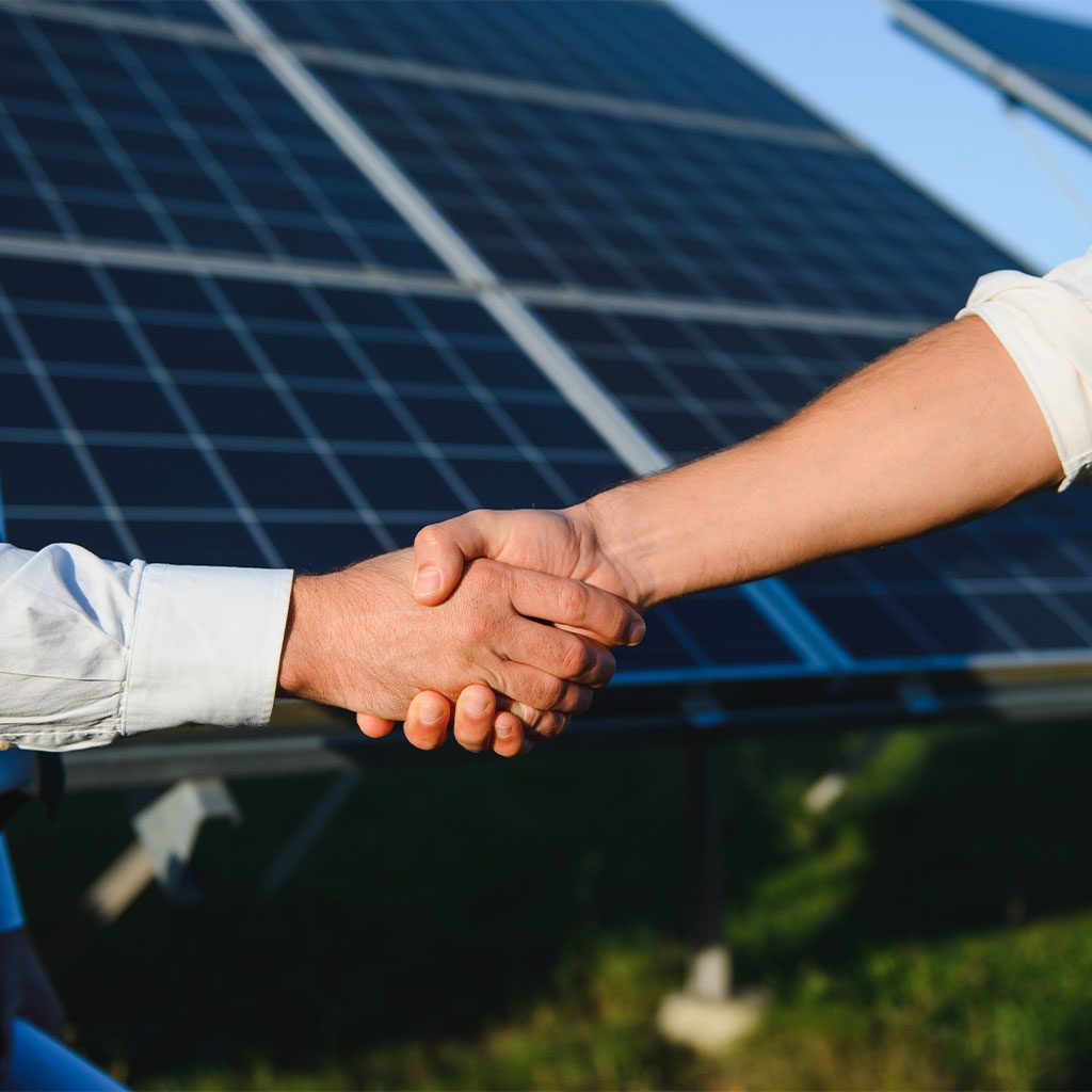 Handschlag vor einer Photovoltaikanlage – persönliche Beratung von Elektrotechnik Polleres