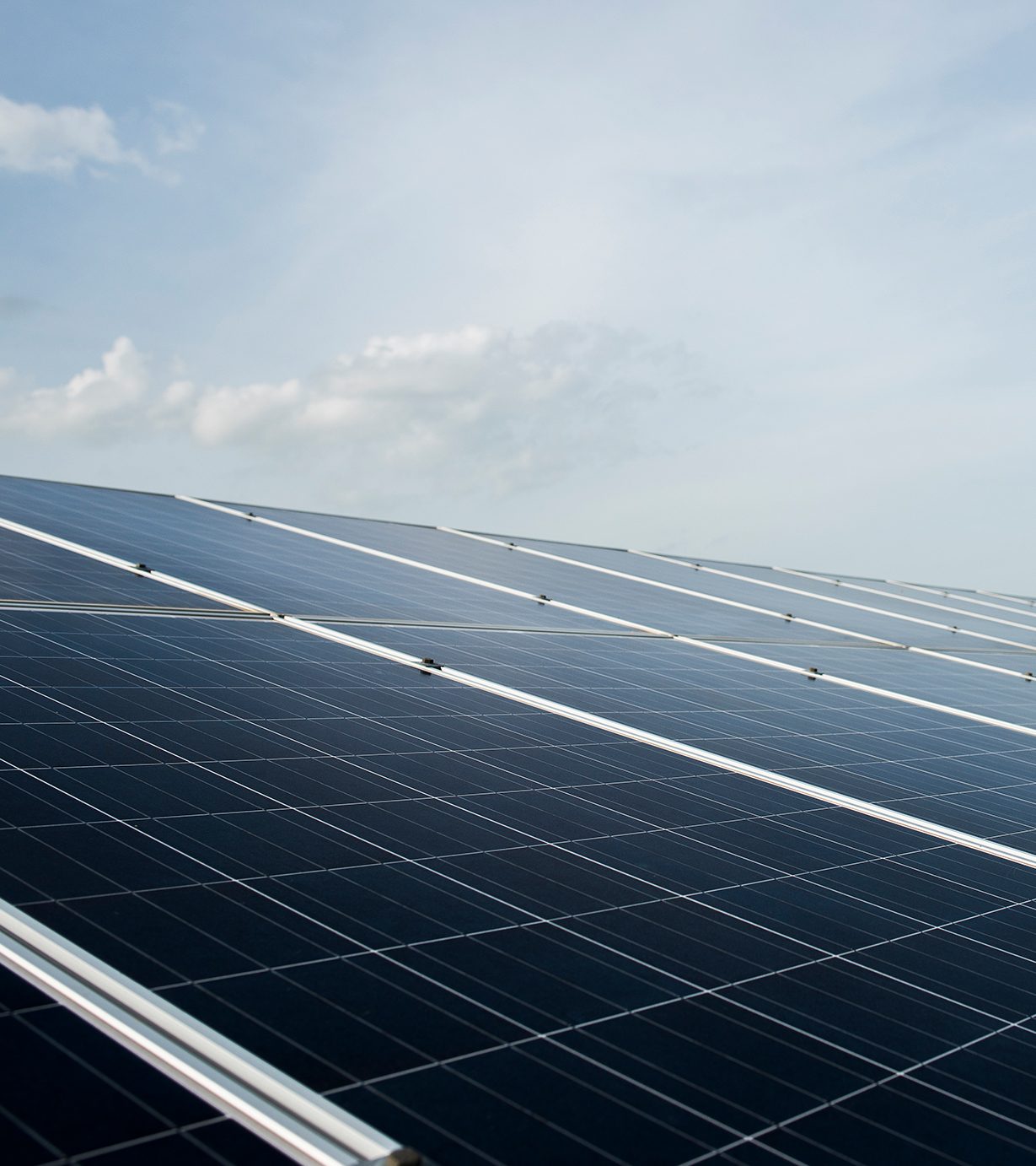 Photovoltaikmodule auf einem Dach vor blauem Himmel